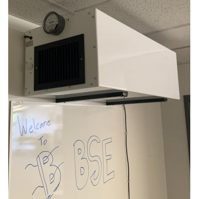 BSE AIRPRO Carbon 1100 CFM Commercial Ambient Air Cleaner installed in an office setting, mounted above a whiteboard.