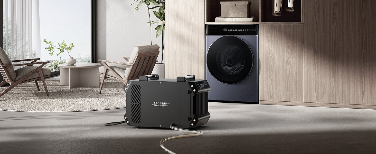 AlorAir Galaxy 60 dehumidifier placed in a laundry room near a washing machine to control indoor humidity