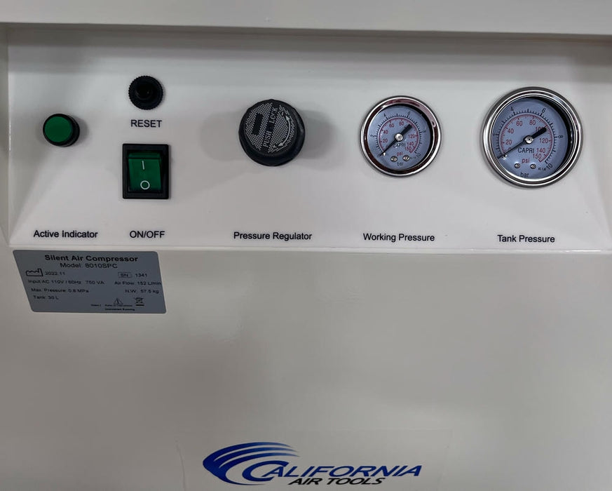Close-up of air compressor control panel showing pressure regulator, gauges, and power controls